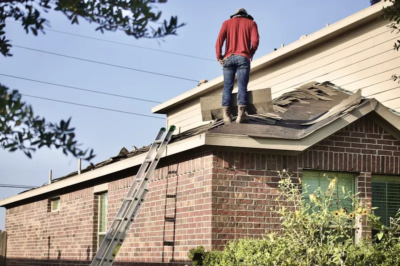 Professional roofer working on a residential roof in Green Acres